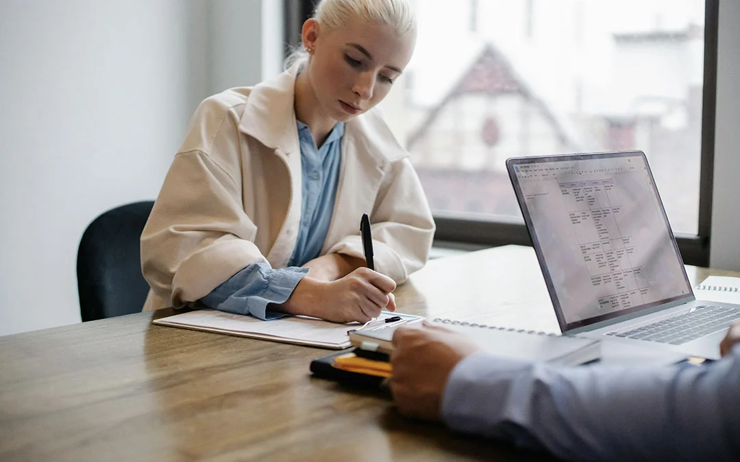 mulher loira assinando documento