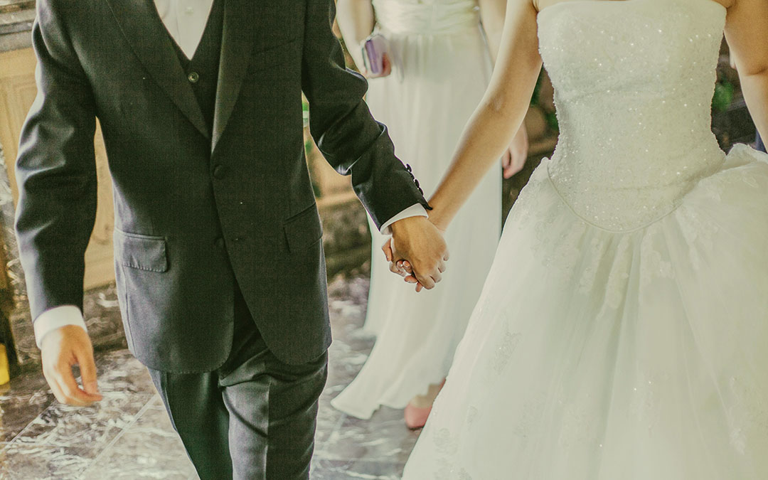 casal de noivos de mãos dadas