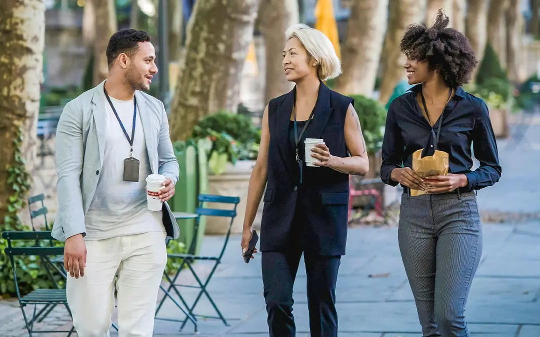 homem com duas colegas de trabalho voltando do almoço