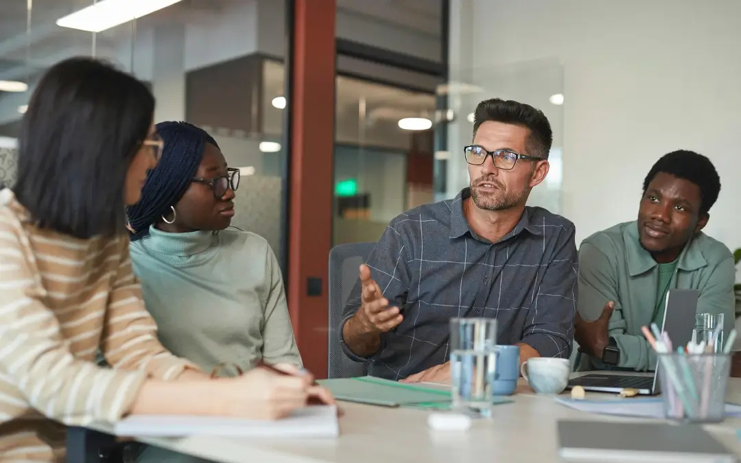 homem falando com outras pessoas em reunião