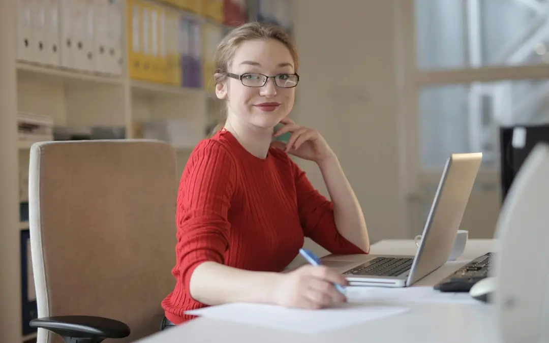 mulher em mesa trabalhando e sorrindo