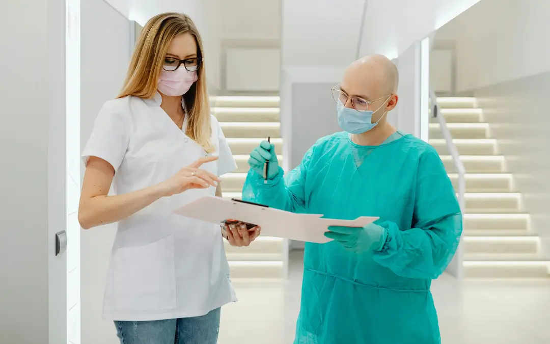 médico e enfermeira olhando prontuários no corredor do hospital