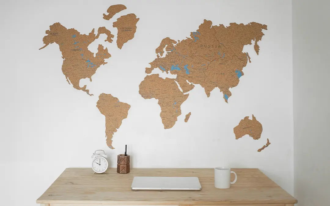 mesa com relógio e mapa mundi na parede