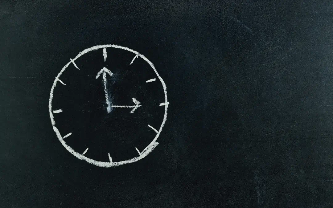 relógio desenhado à giz em lousa preta