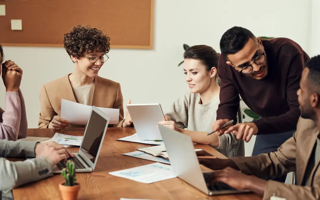 mulher líder de equipe sorrindo e conversando com equipe em reunião