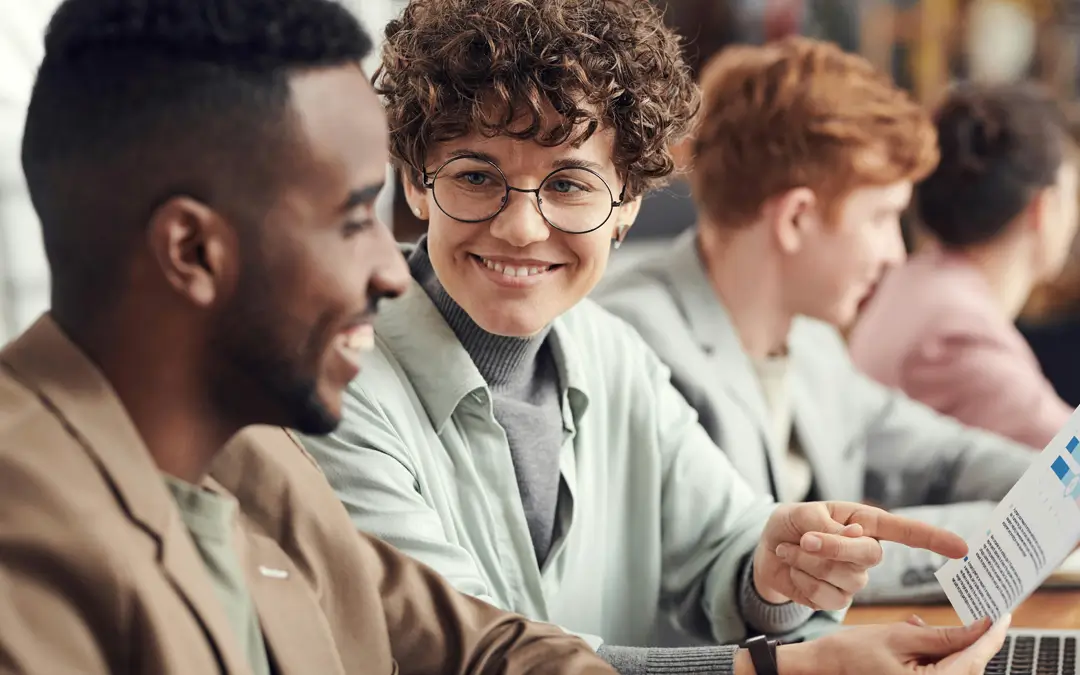 mulher sorrindo e olhando admirada para colega de trabalho