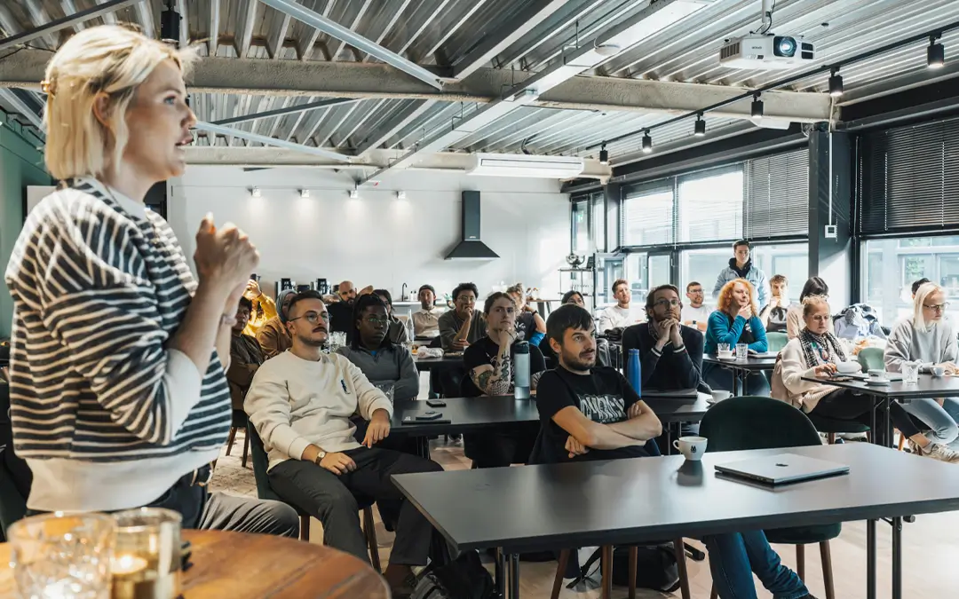 mulher palestrando para funcionários em ampla sala