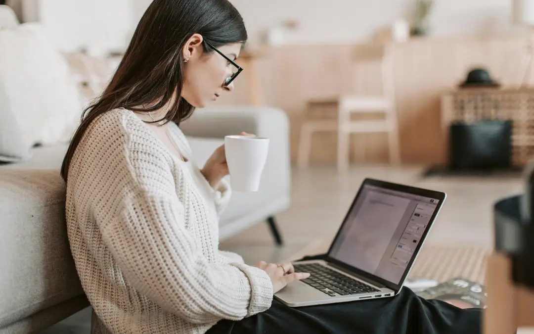 mulher jovem com caneca estudando de frente com laptop
