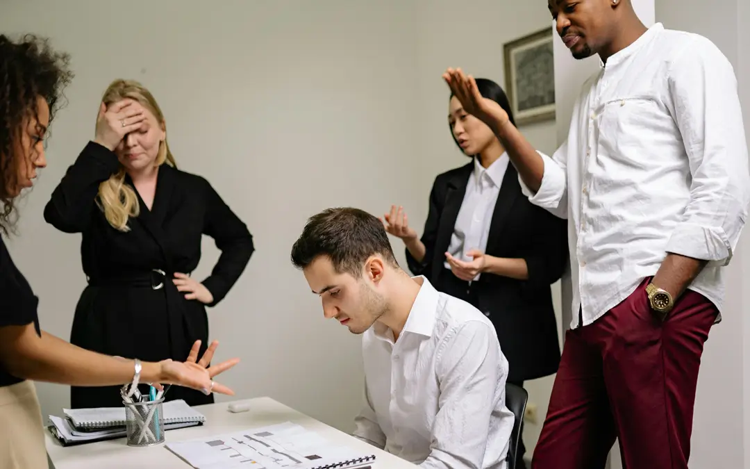 homem sofrendo assédio moral de colegas de trabalho