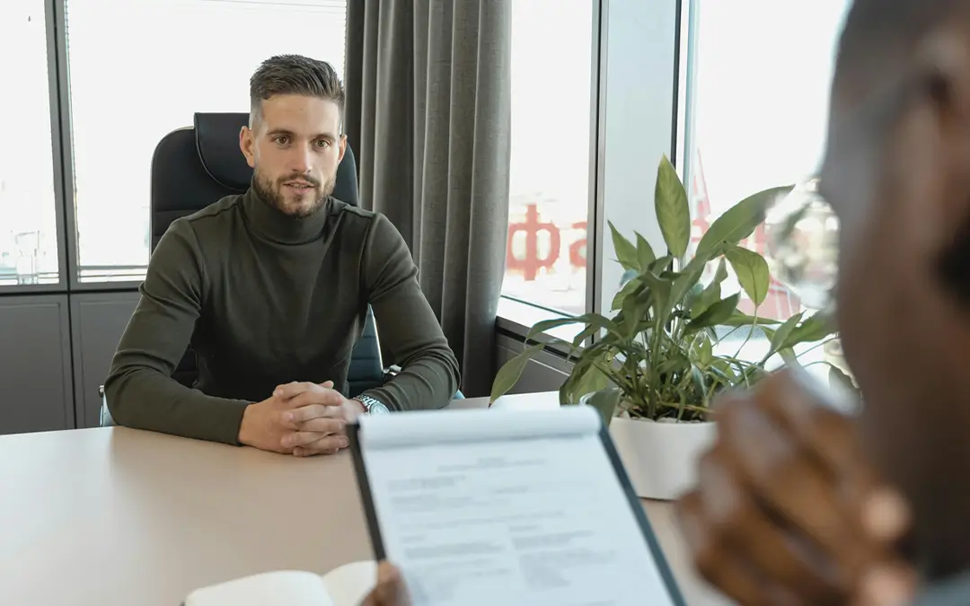 homem jovem observando contratante analisando seu curriculo