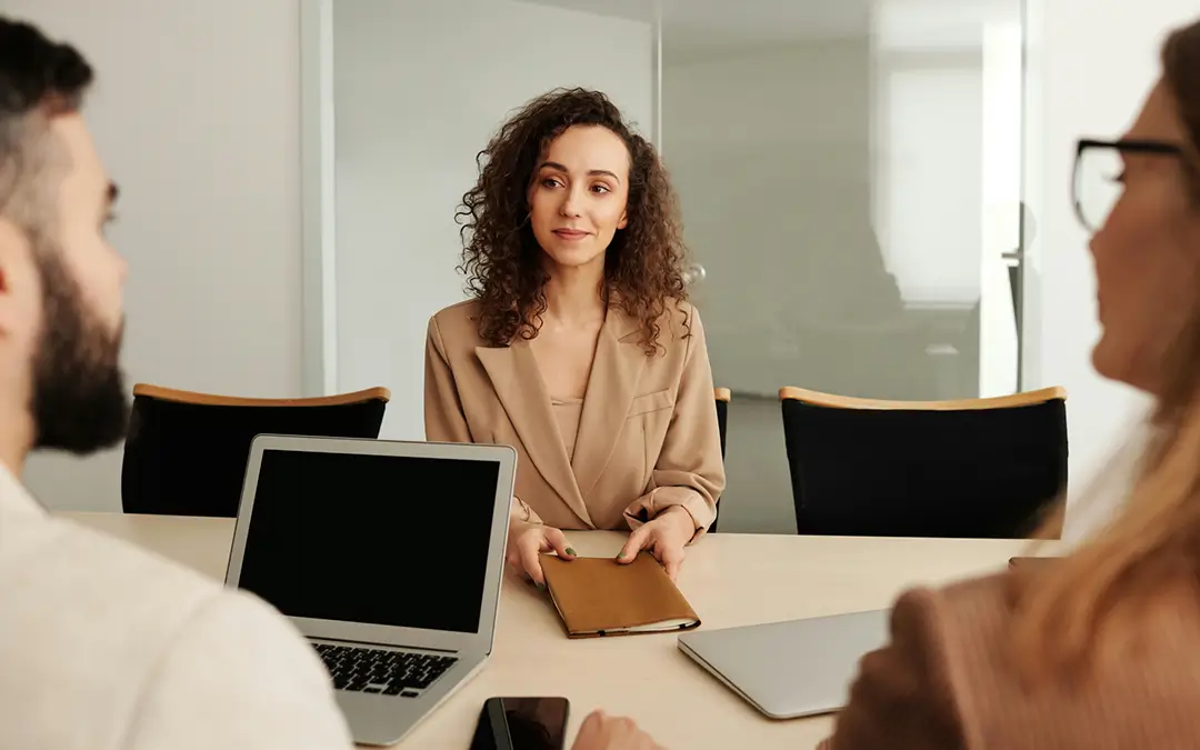 mulher jovem adulta sendo entrevistadas por duas pessoas