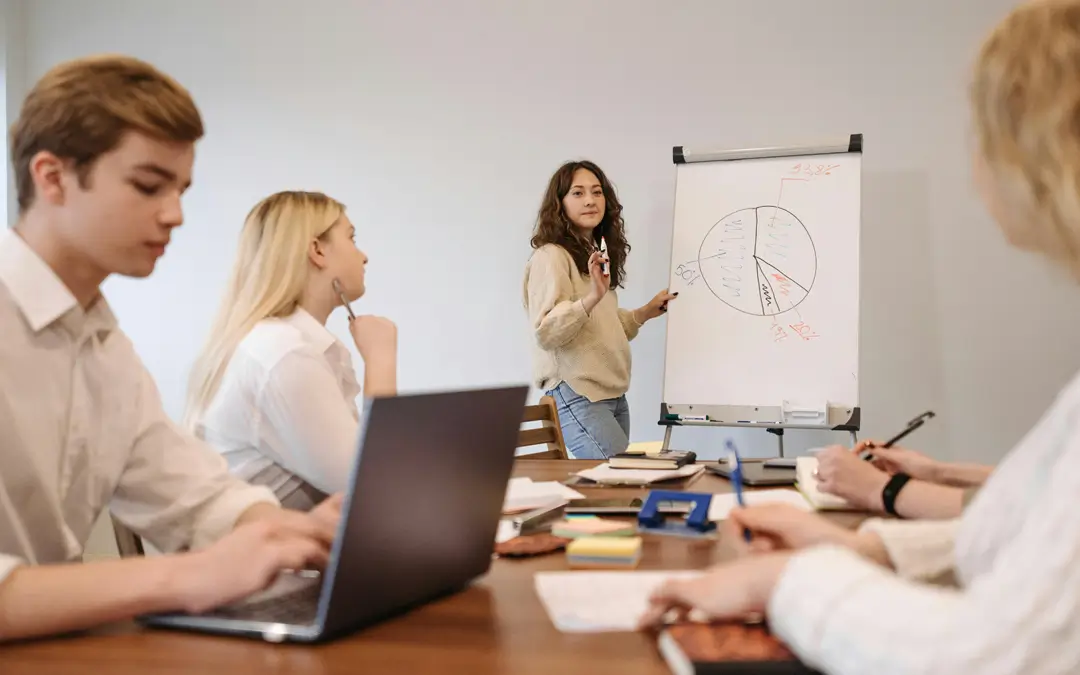jovem mulher de pé em reunião apresetando gráficos em flipchart