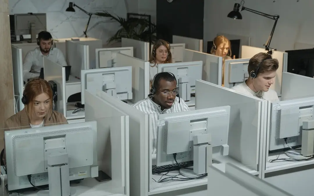 baias de call center com pessoas trabalhando
