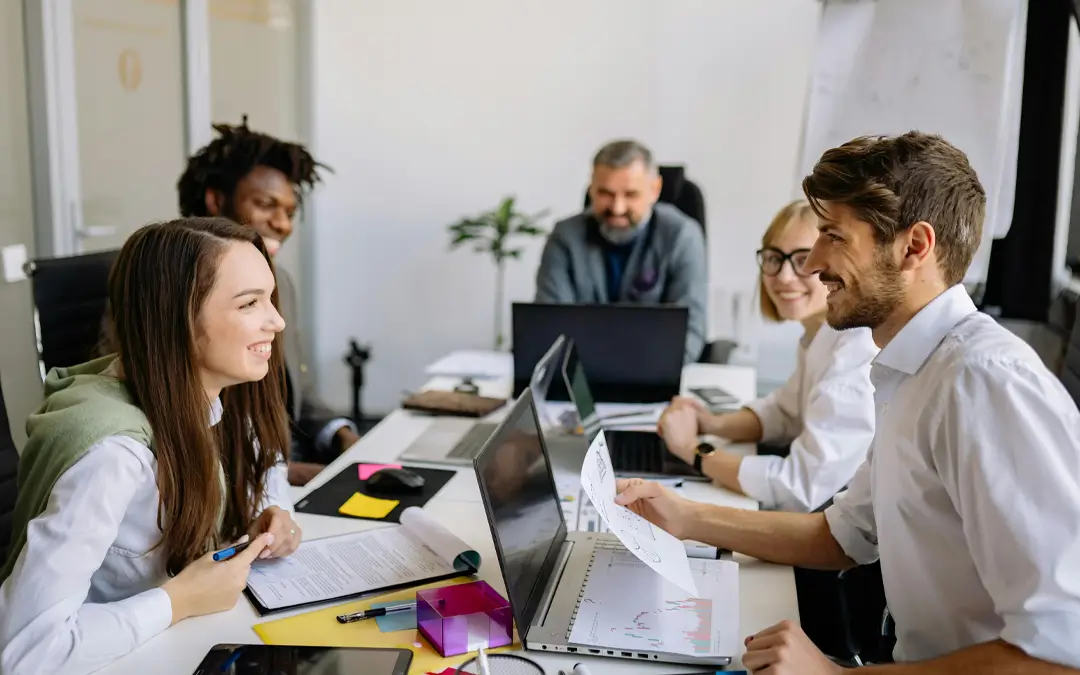 colegas de trabalho sorrindo em reunião com chefe