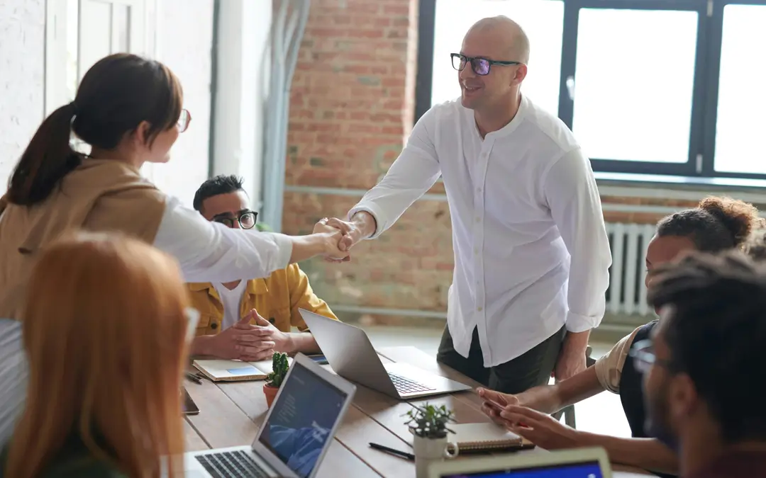 chefe cumprimentando funcionário promovida