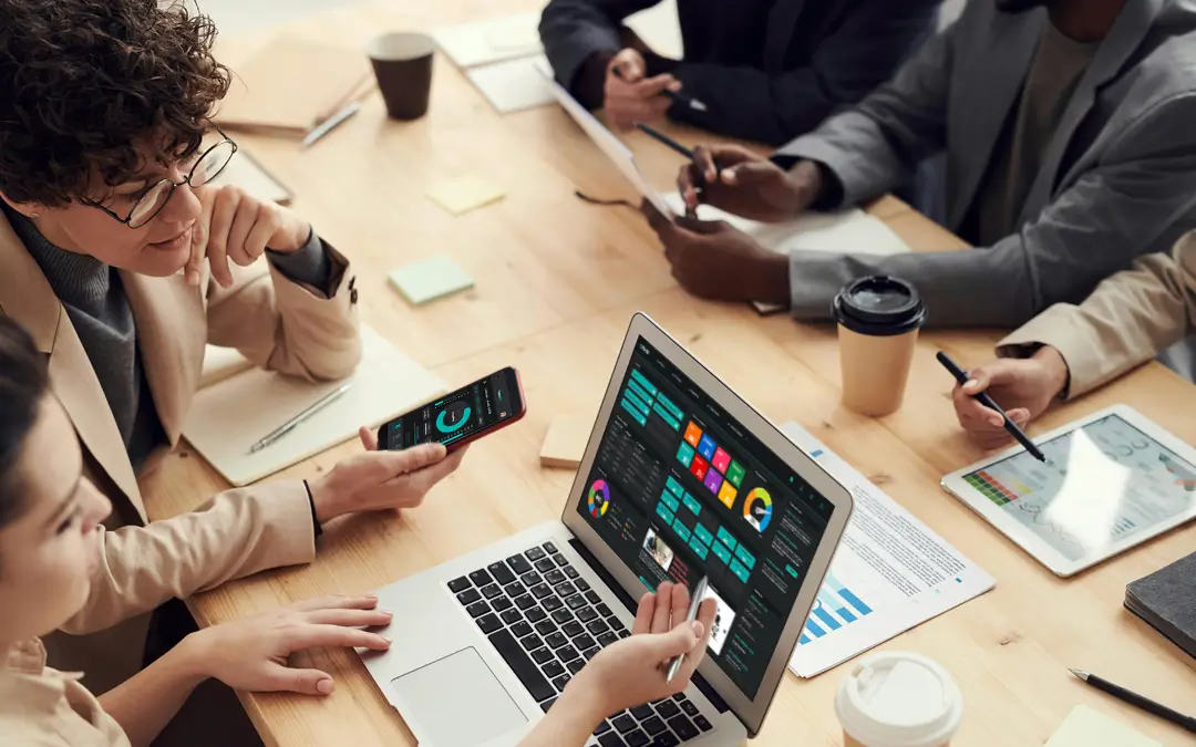 gestoras de rh analisando gráficos em laptop na reunião