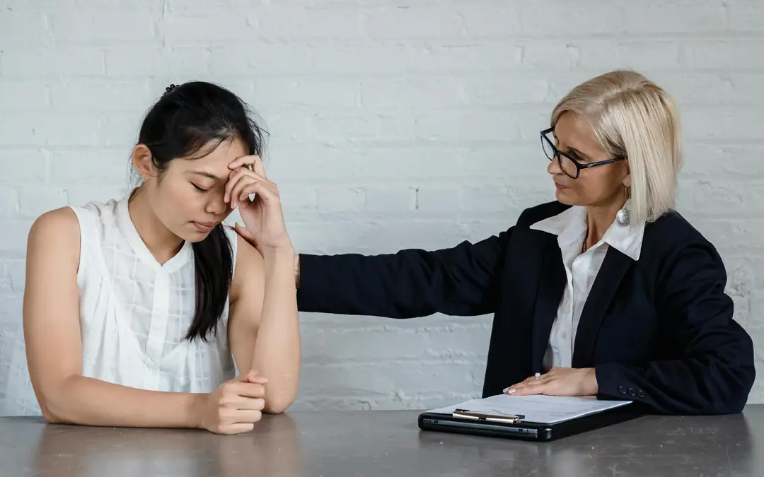 gestora de RH com a mão nas costas de funcionária em apoio