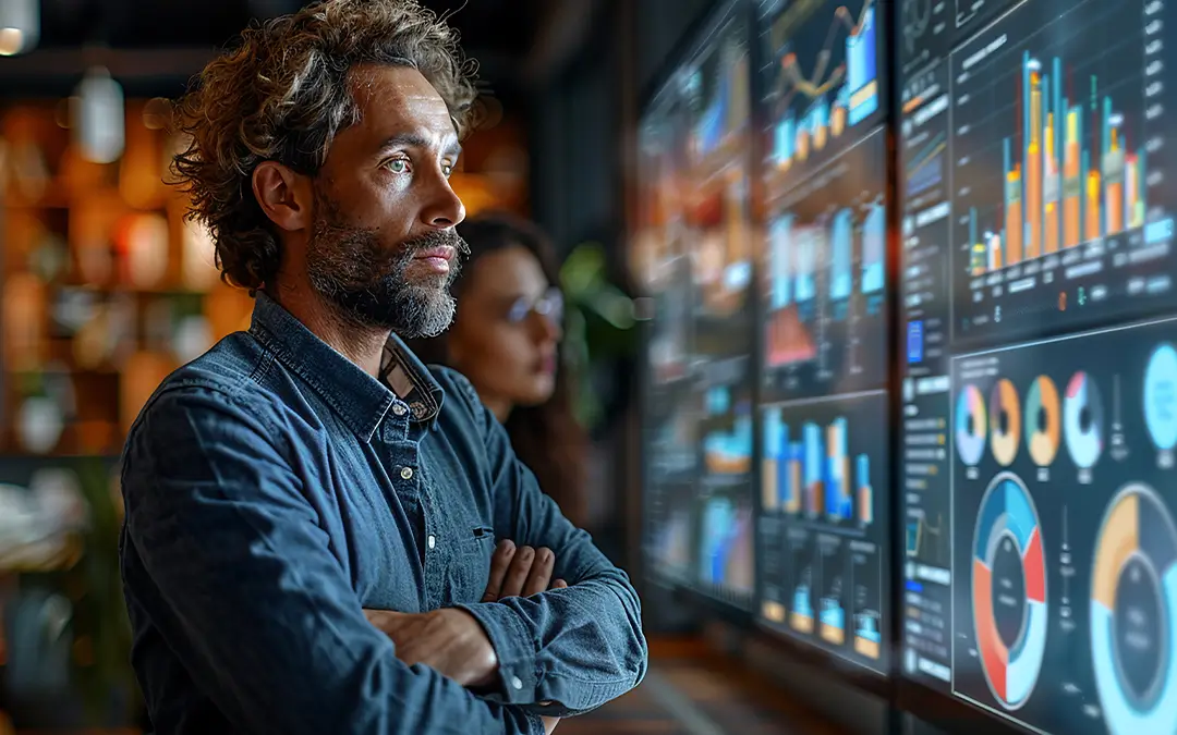 homem gestor analisando painel com gráficos