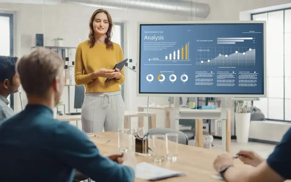 gestora de RH apresentando gráficos em grande tela para diretoria