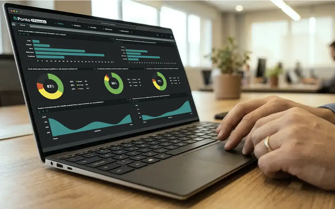 mãos sobre teclado de laptop com gráficos de pesquisa de clima organizacional