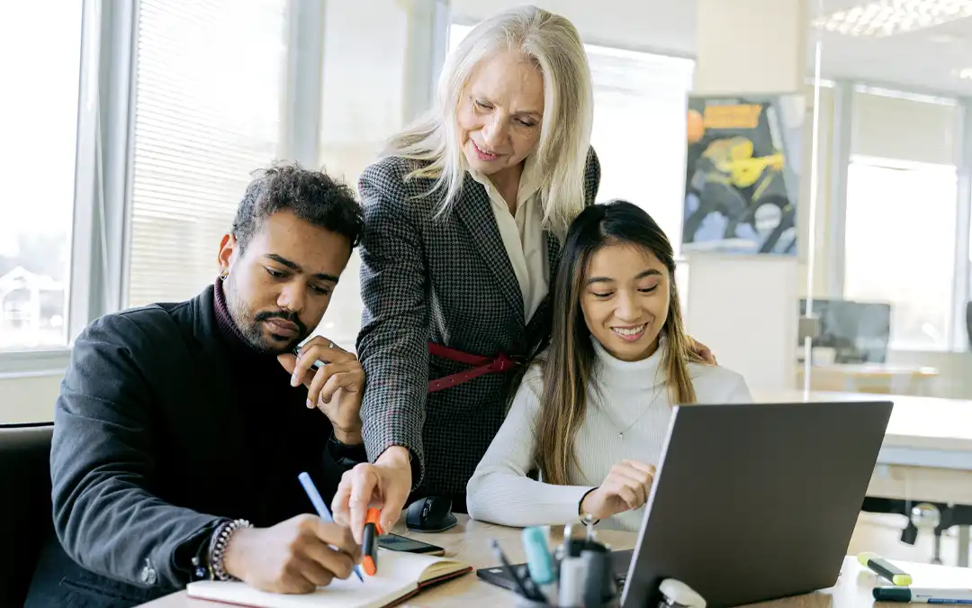 mulher de meia idade ensinando colegas de trabalho jovens