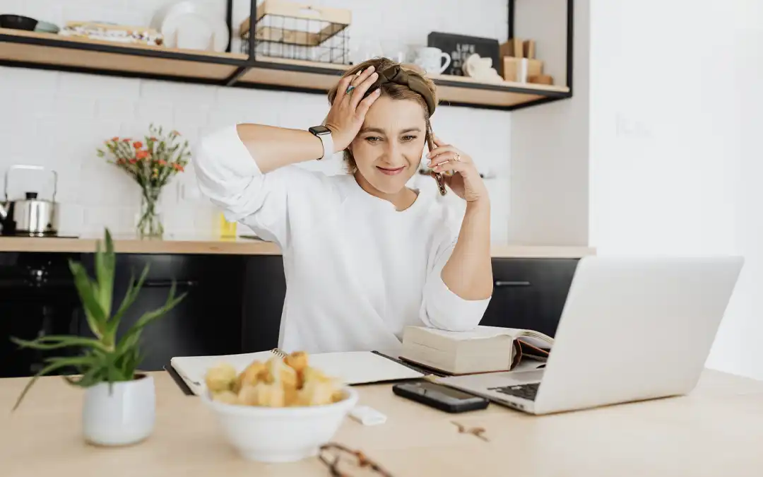 Mulher trabalhando com laptop na cozinha de casa